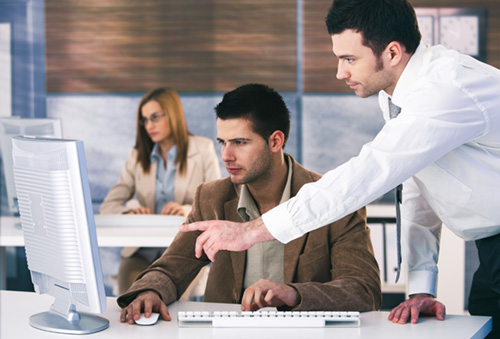 Support technician teaching a client how to use the PowerTime system on their desktop computer